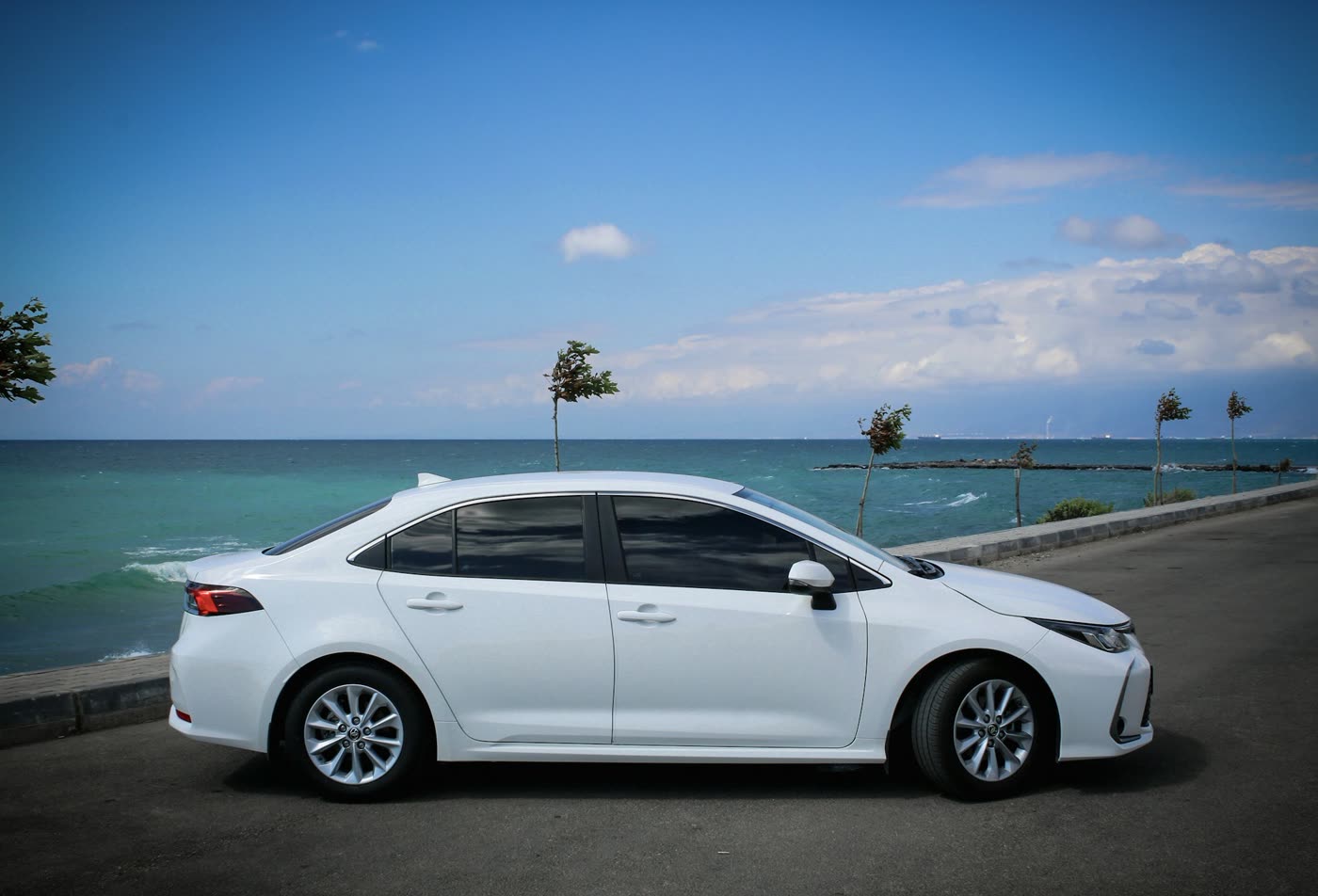 White Toyota Corolla parked by the sea