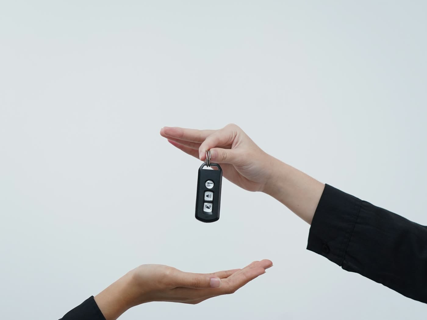 A car key passing from one hand to another